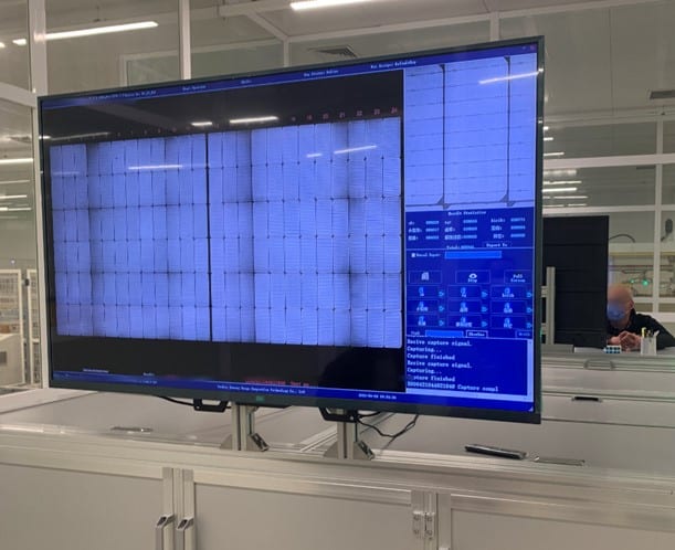 Ekran görüntüsü: fabrikada birden fazla panelin EL test görüntülerini gösteren büyük monitör