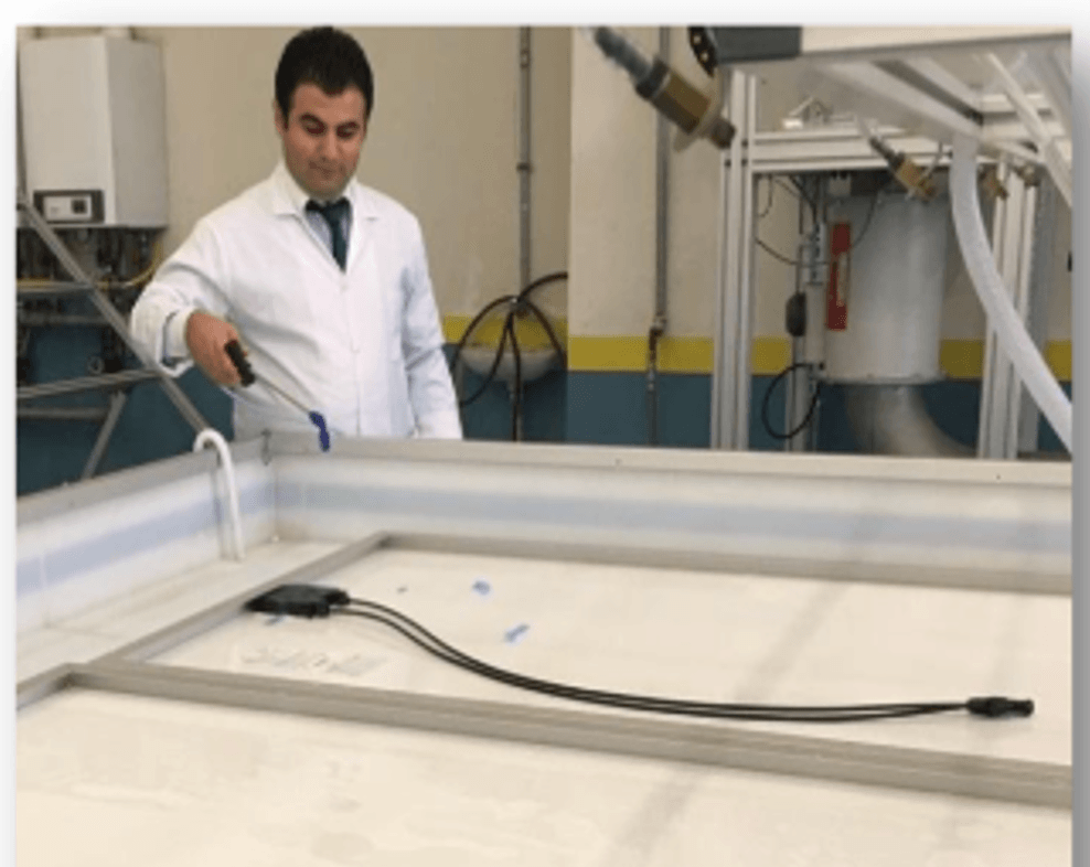 Bir teknisyen yaş kaçak akım deneyi için modülü su dolu bir tekne içinde test ediyor